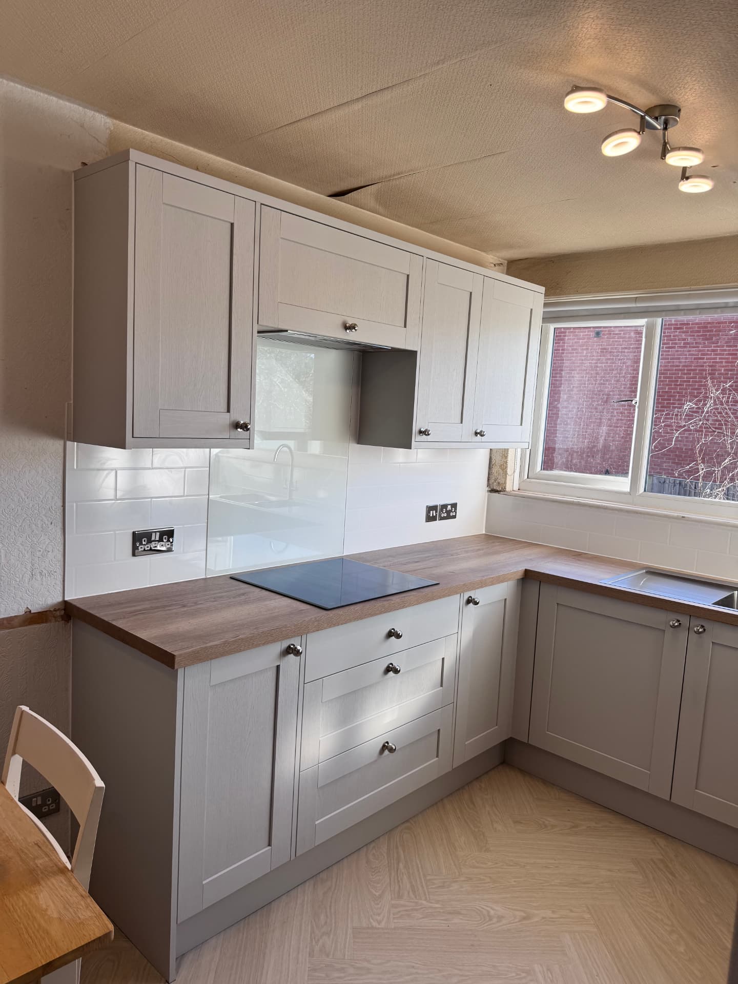 Grey shaker kitchen with oak effect worktops and metro tile splashback