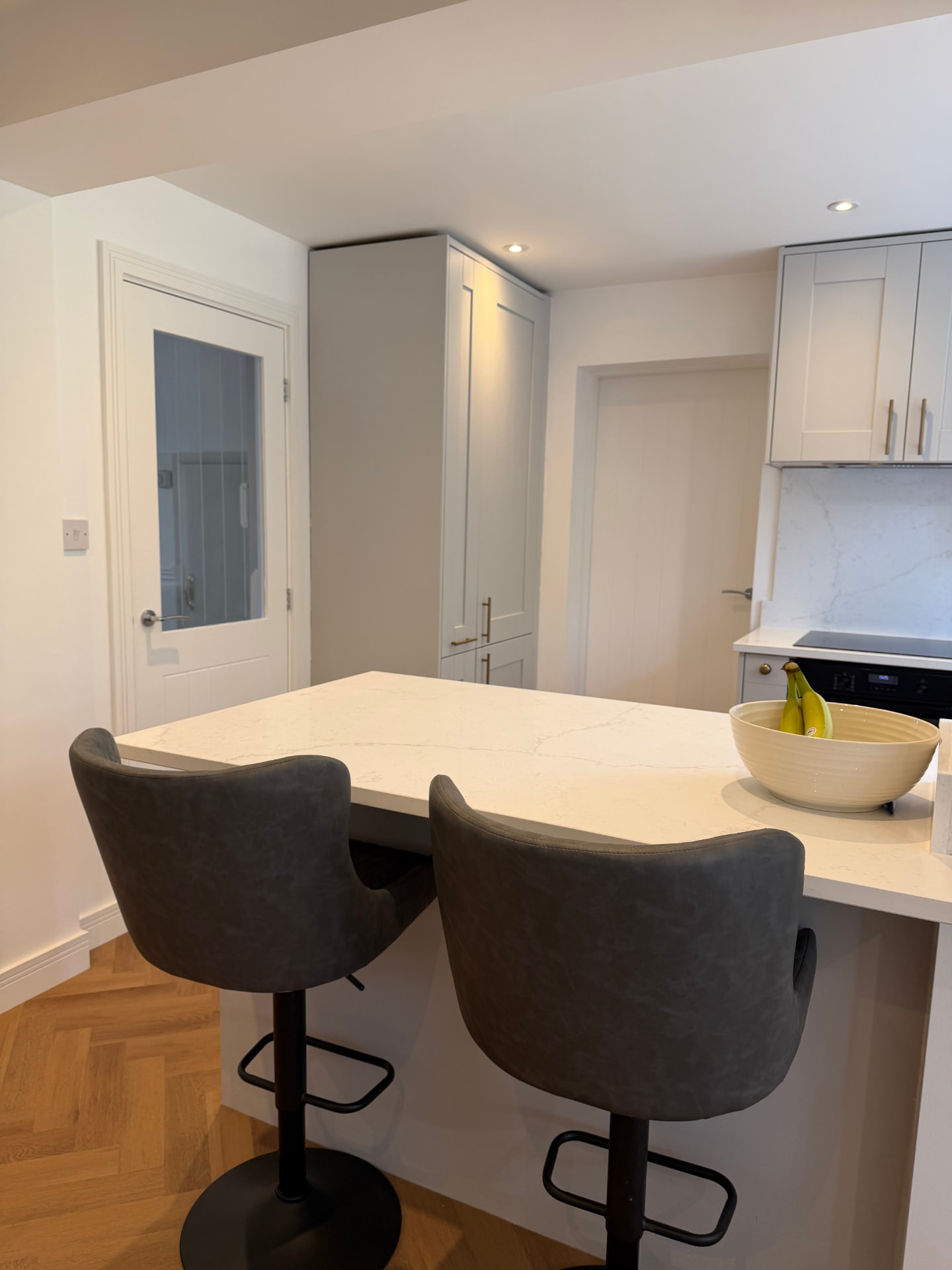 Breakfast bar with stools looking towards the hallway