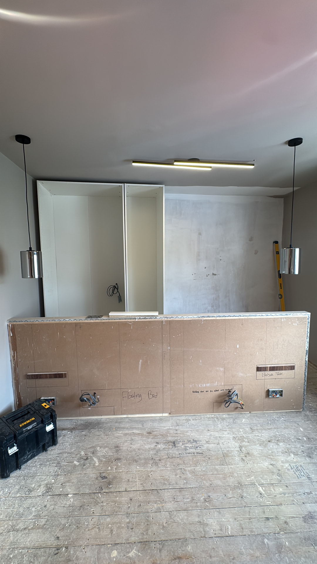 Headboard wall boarded with wardrobe carcasses behind