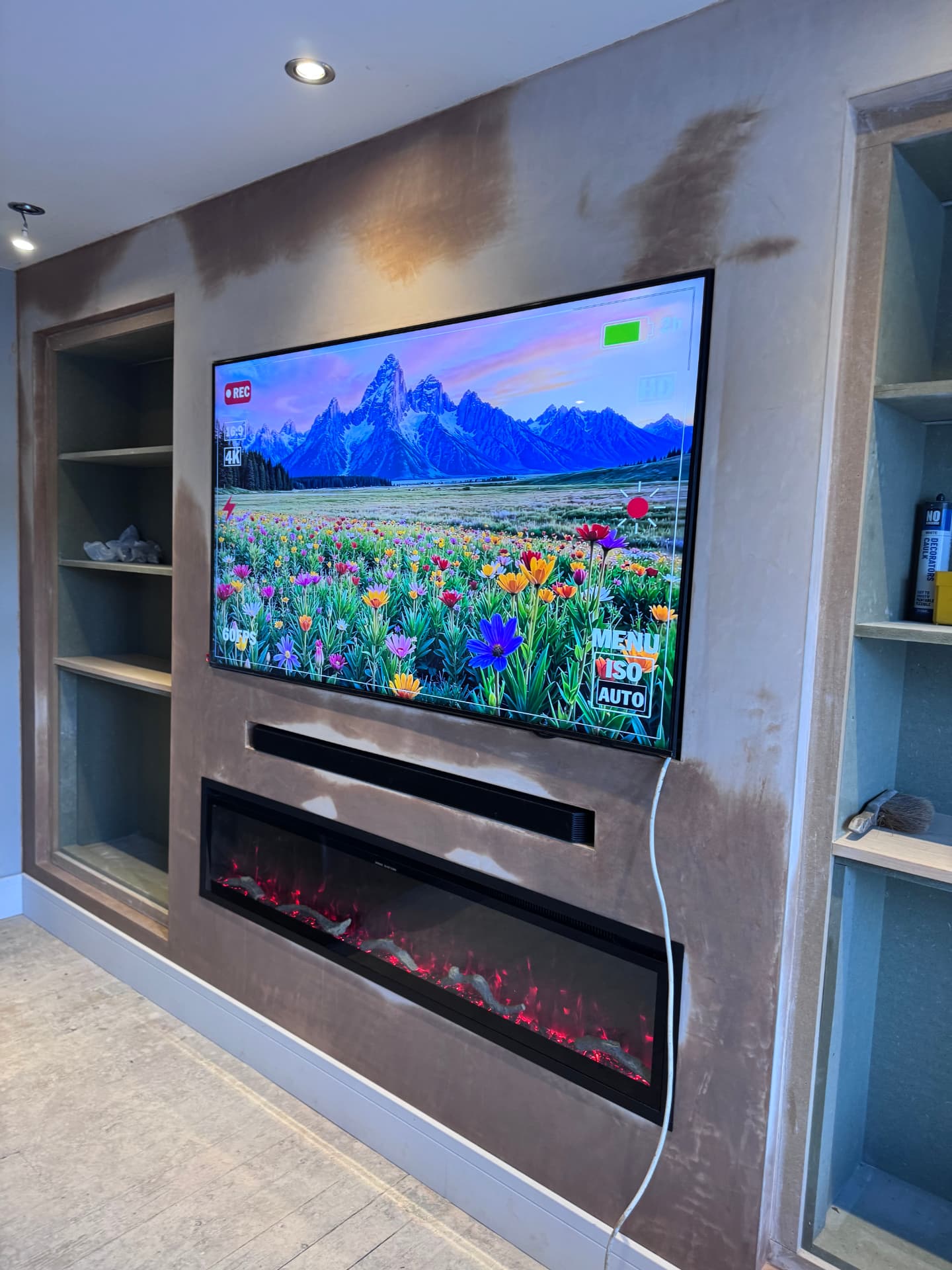 Plastered media wall with inset electric fire, soundbar recess and alcove shelving
