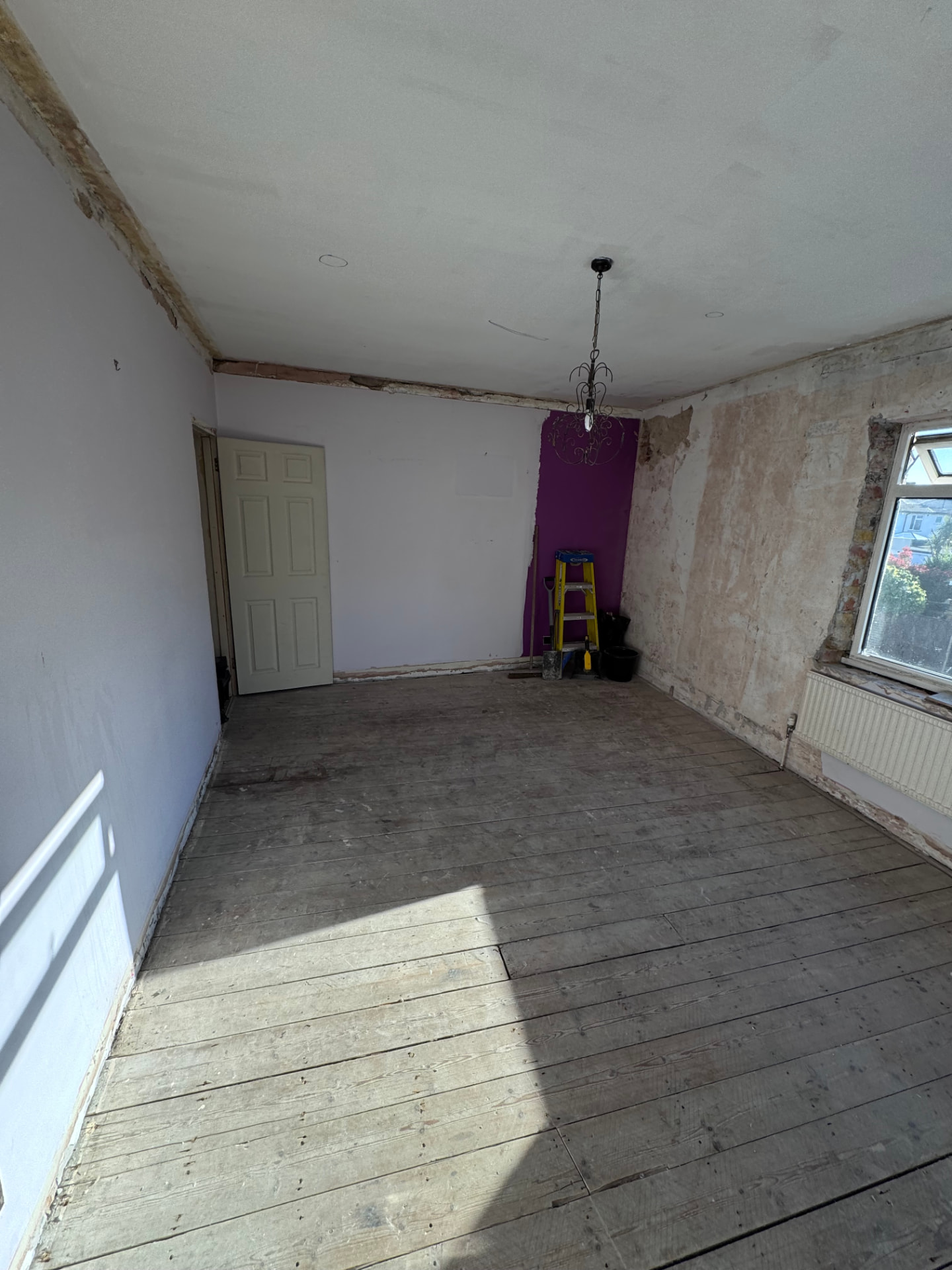Bedroom cleared with skirtings removed and plaster hacked back
