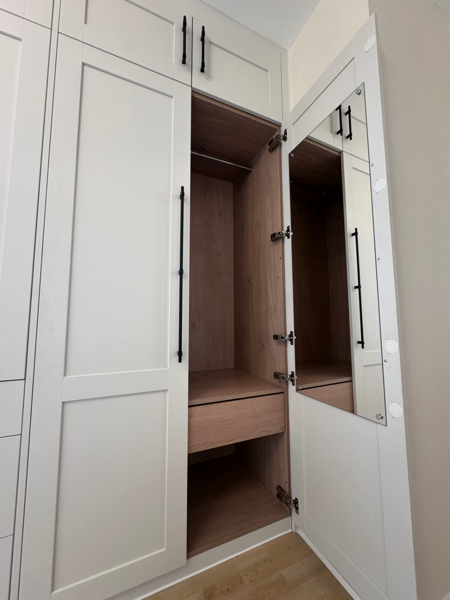 Fitted wardrobe with mirrored inner door and oak shelving