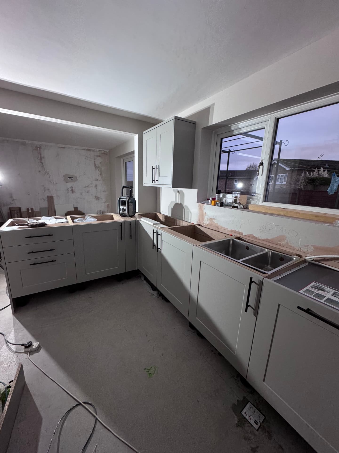 Kitchen units set out with sink and worktop templating underway