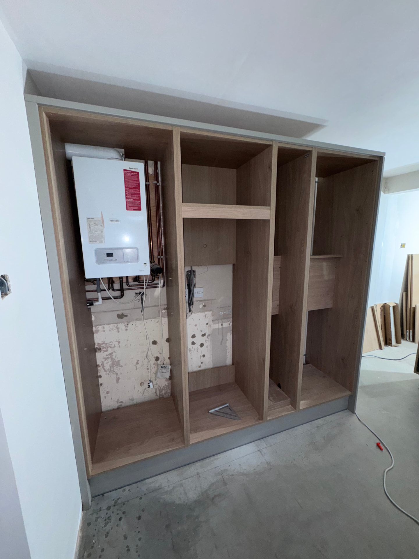 Bespoke tall unit carcasses built to conceal the relocated boiler