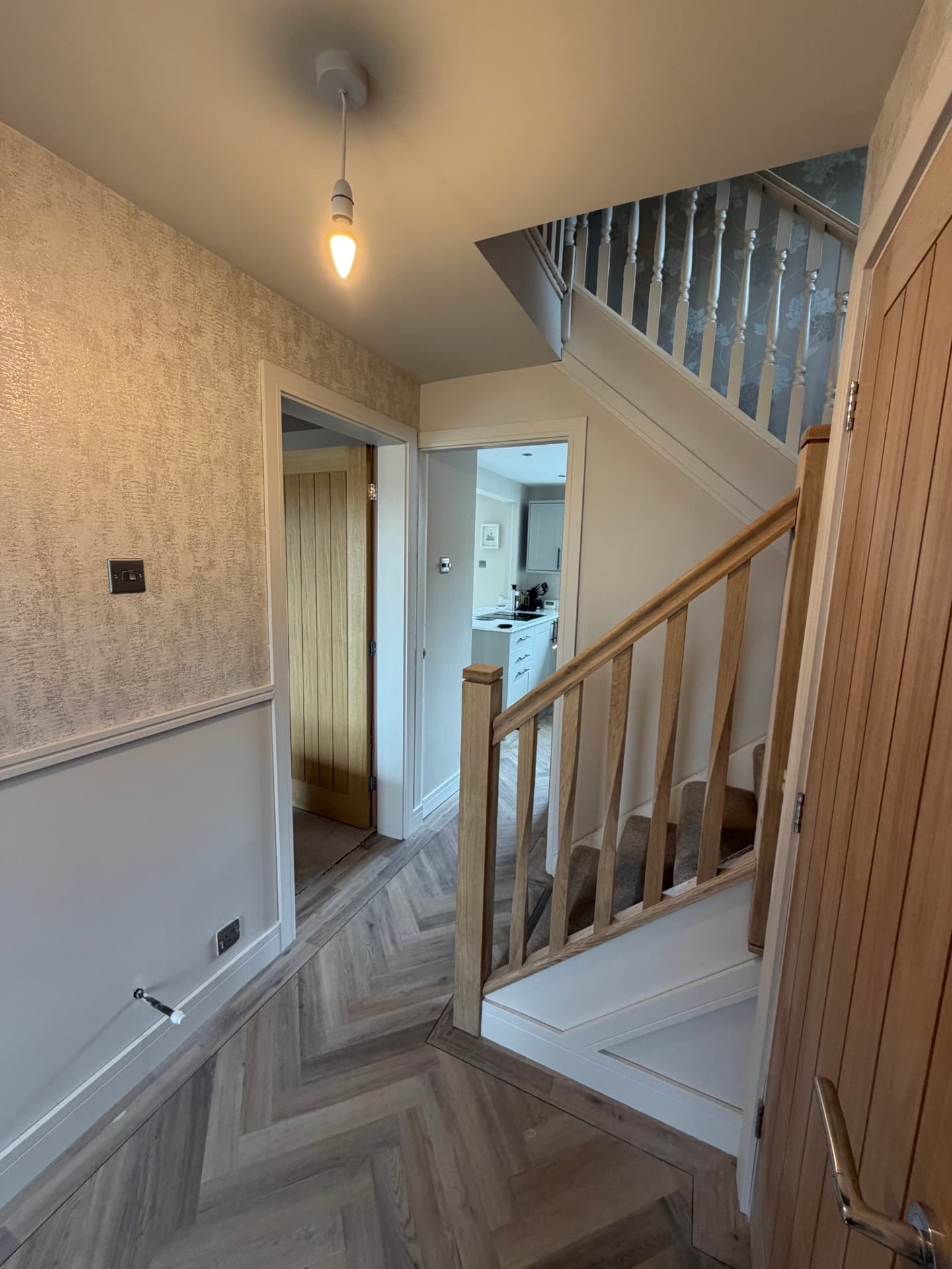 Finished hallway looking through to the kitchen with oak balustrade