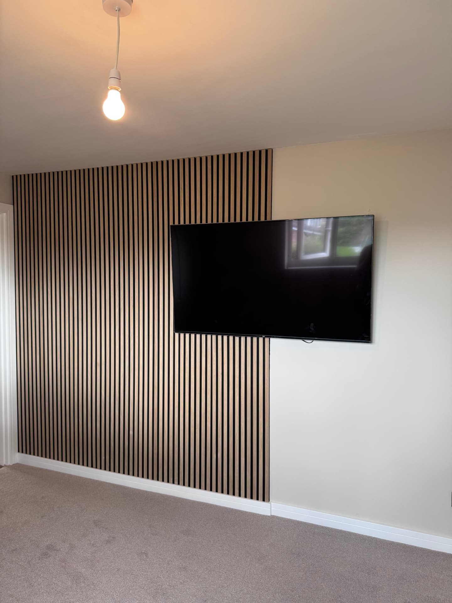 Oak slatted feature wall with wall-mounted TV