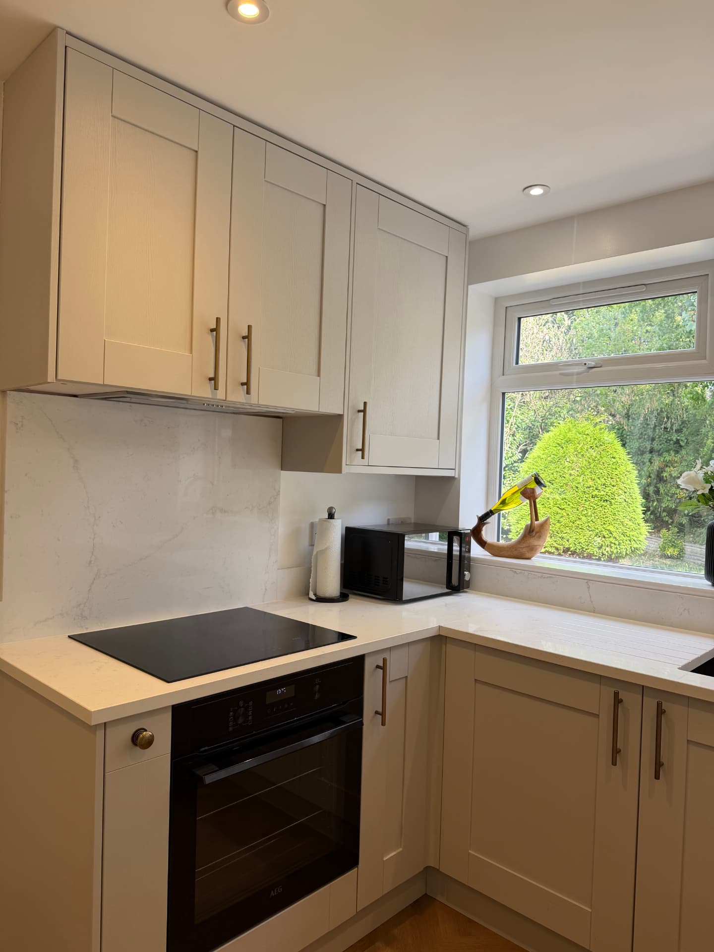 Finished kitchen run with induction hob and stone splashback