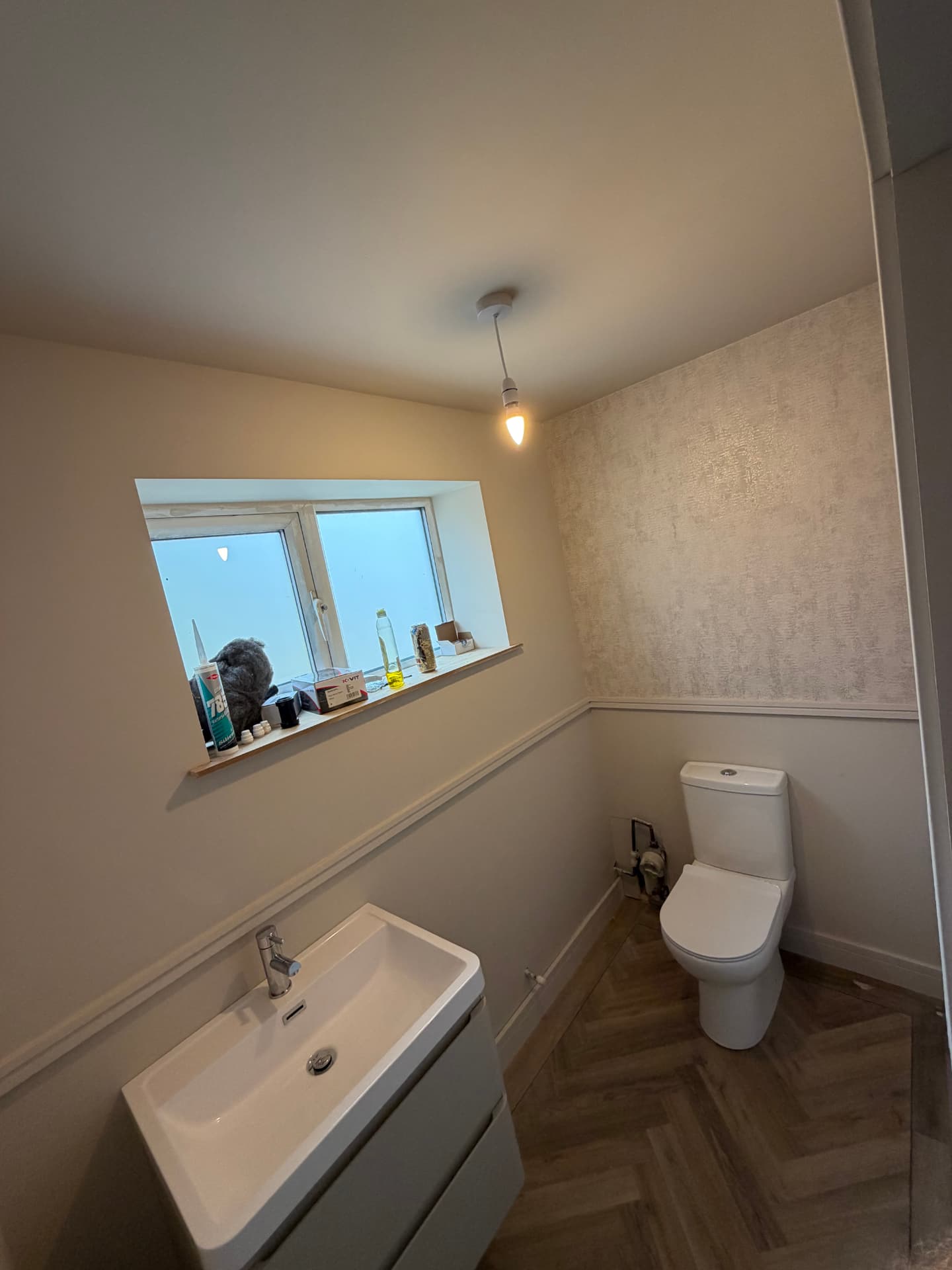 Finished downstairs WC with wall-hung vanity and herringbone flooring