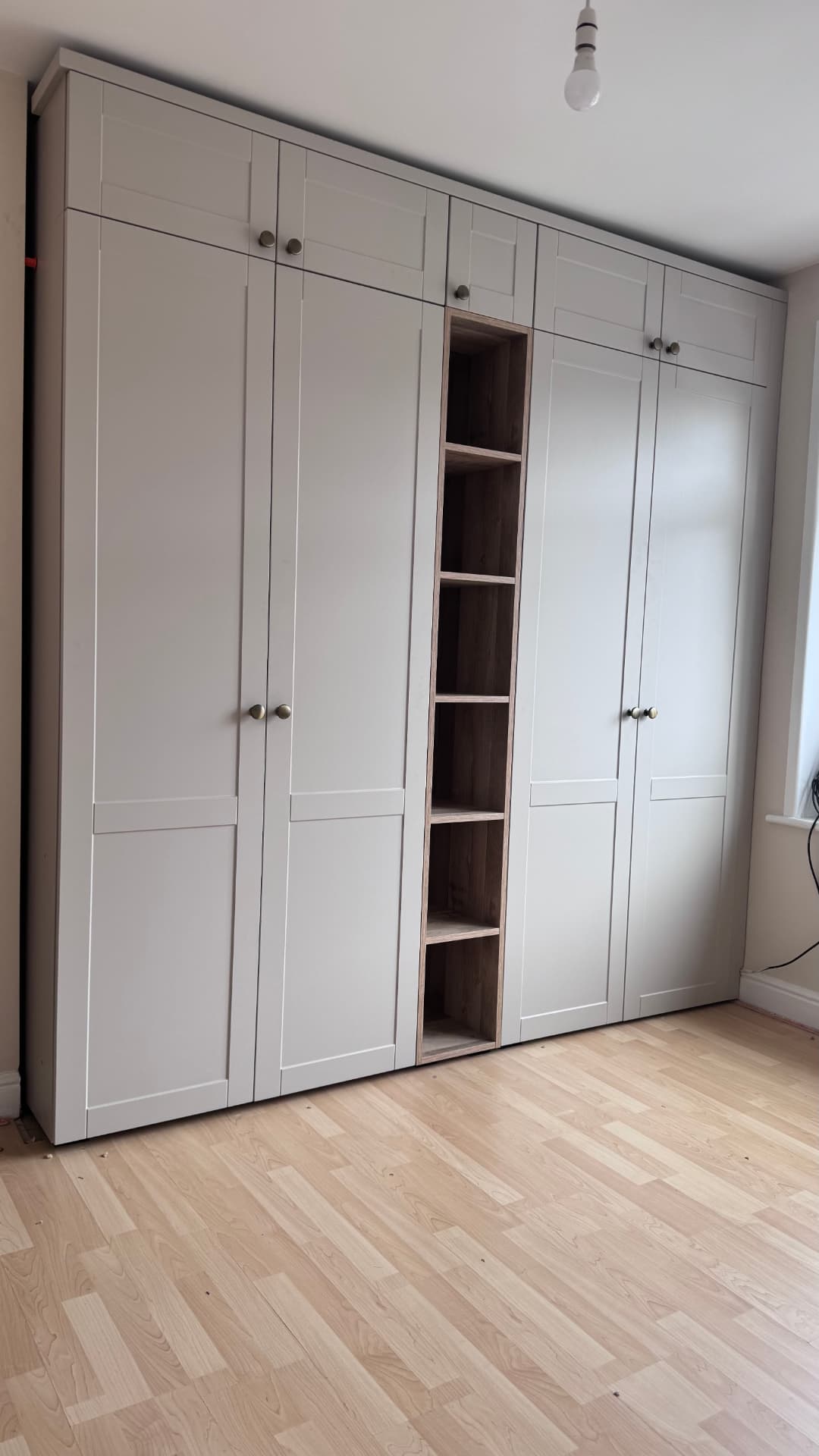 Grey shaker fitted wardrobes with open oak shelving column