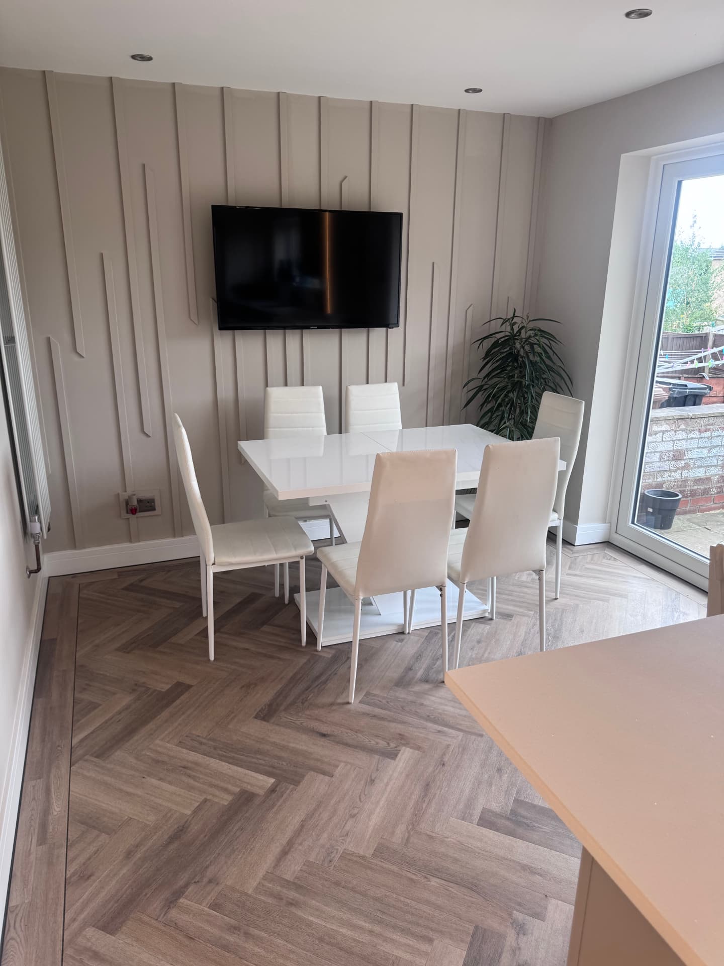 Finished dining area with panelled feature wall and herringbone flooring