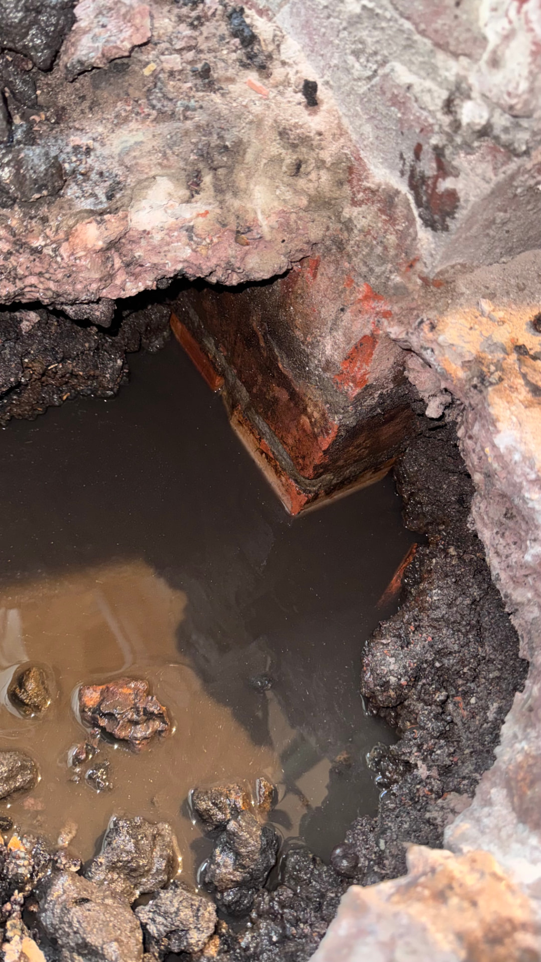 Excavation filled with groundwater beside the existing brick footings