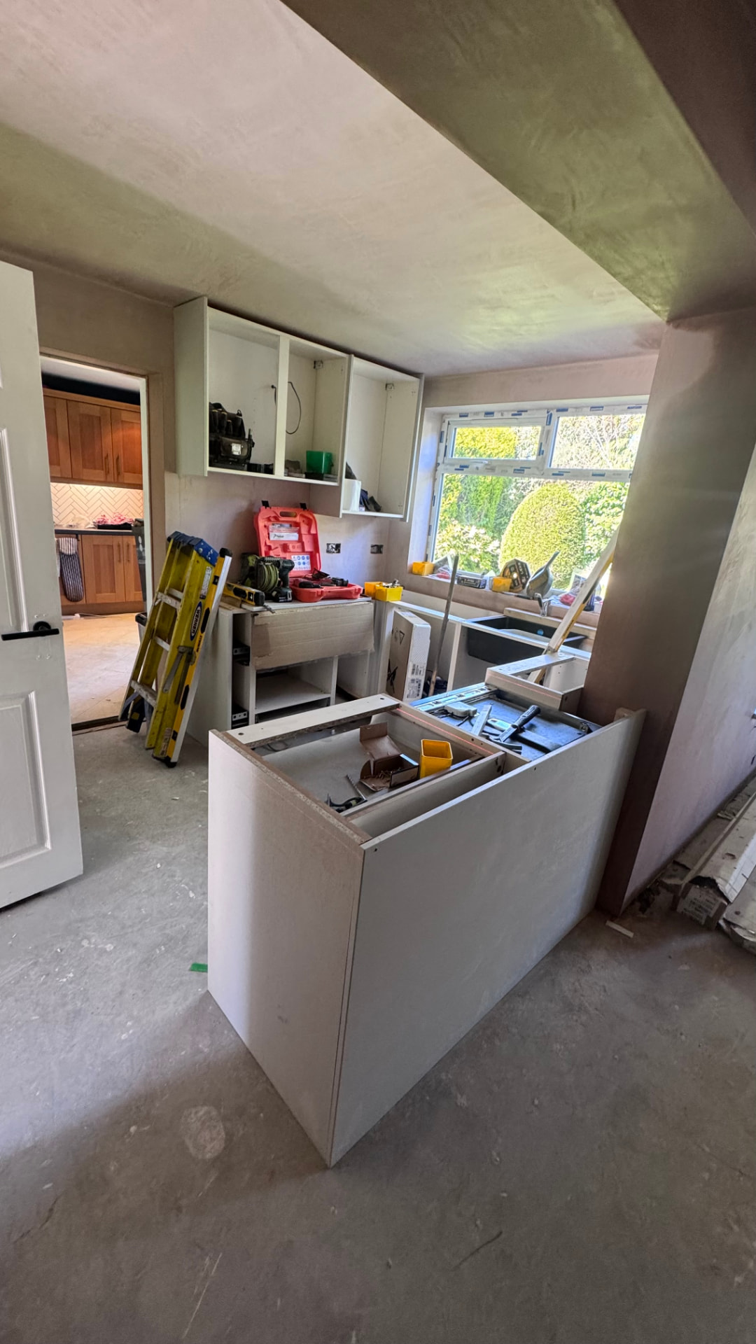 Kitchen units being set out against freshly plastered walls