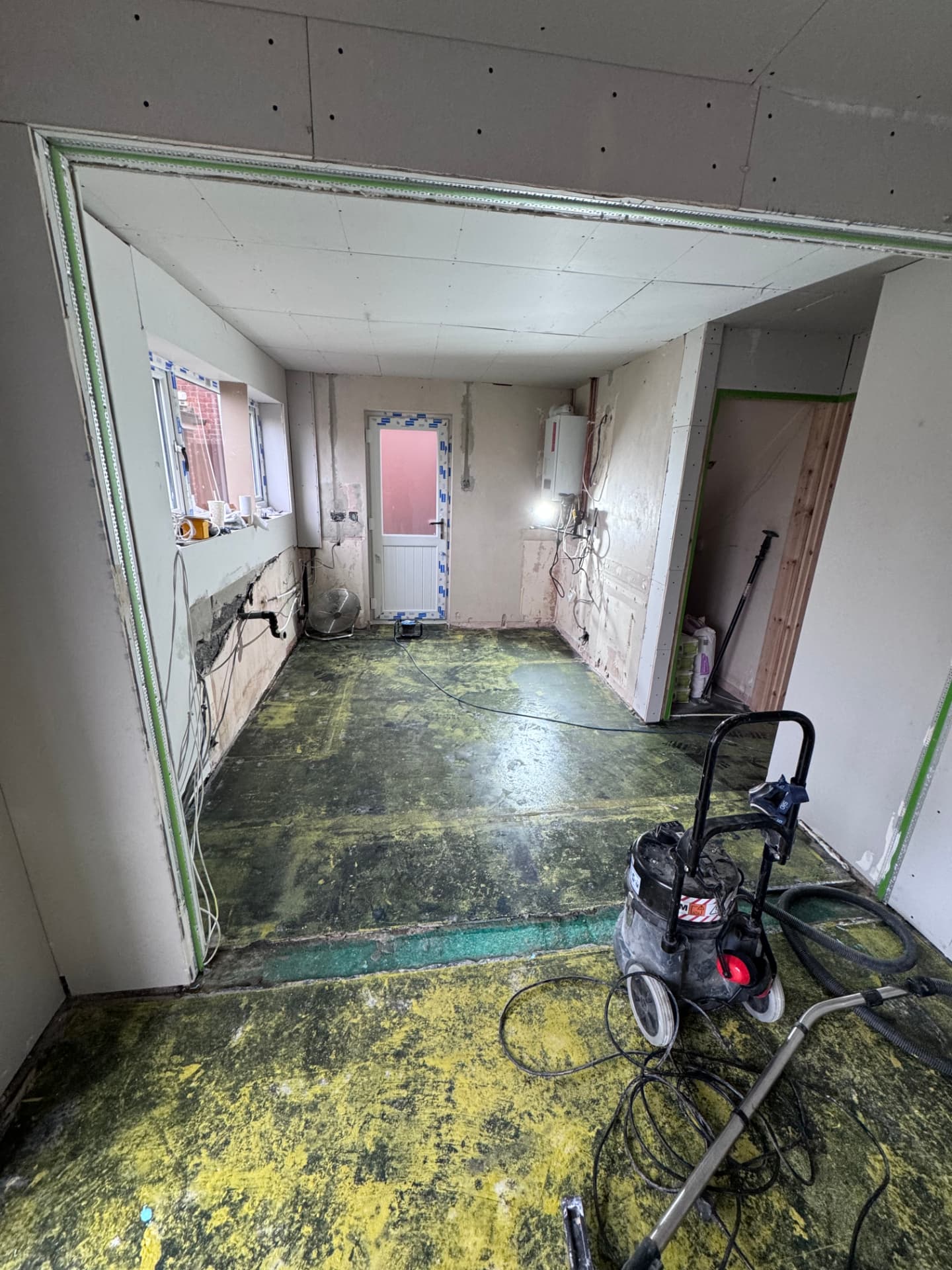Kitchen area boarded out with first-fix pipework and wiring in place