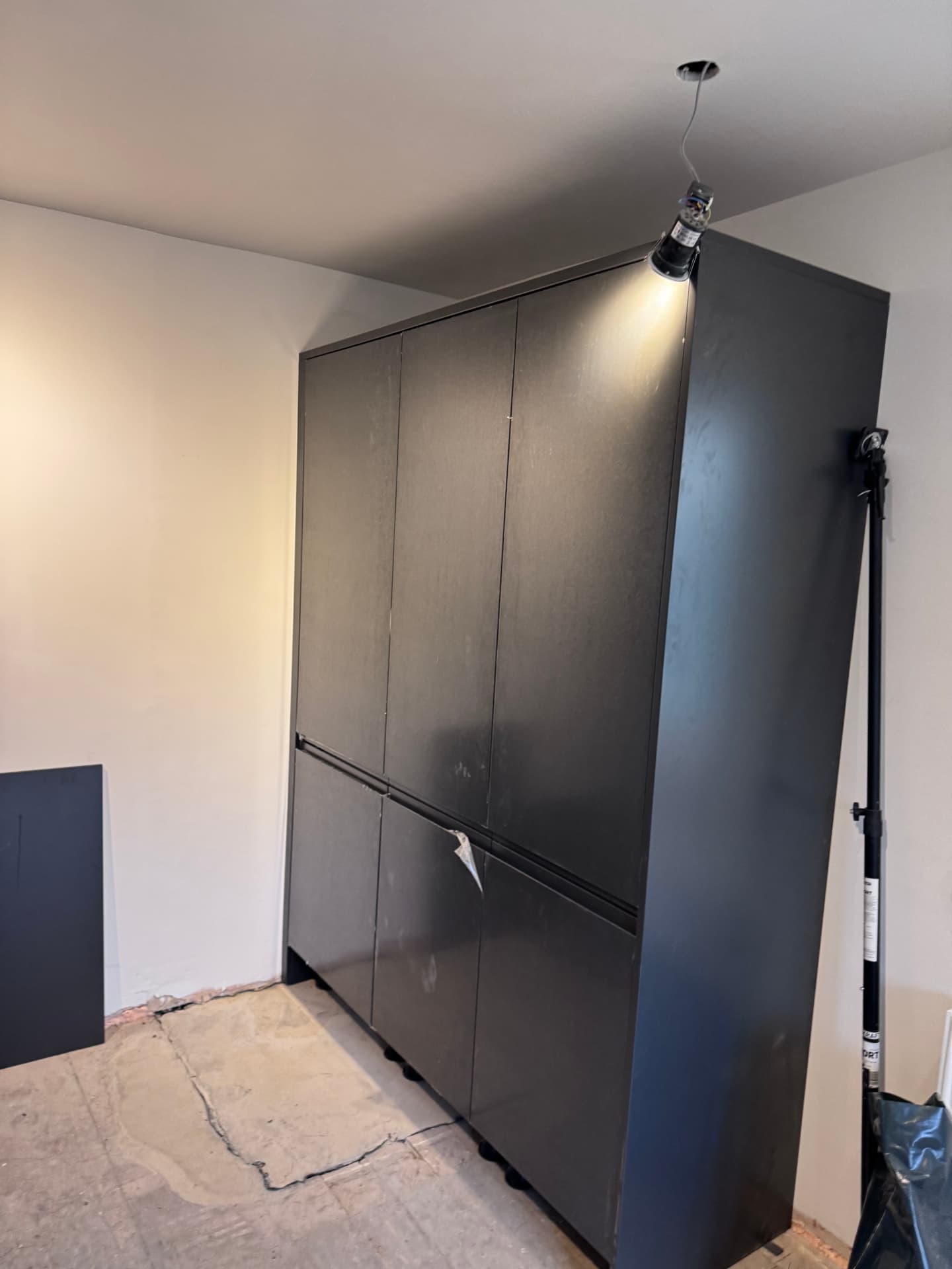 Dark grey tall kitchen units installed during a fit-out