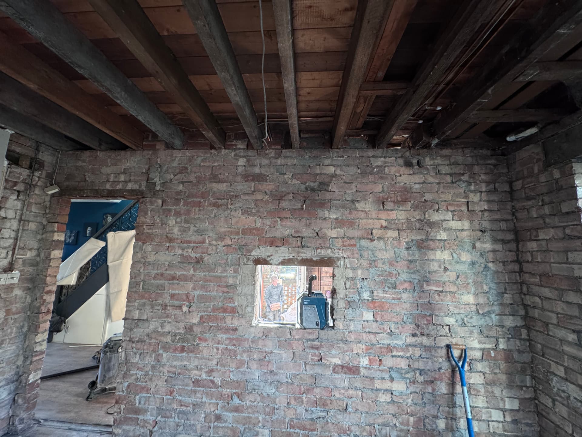Brick wall exposed with ceiling joists open for first fix