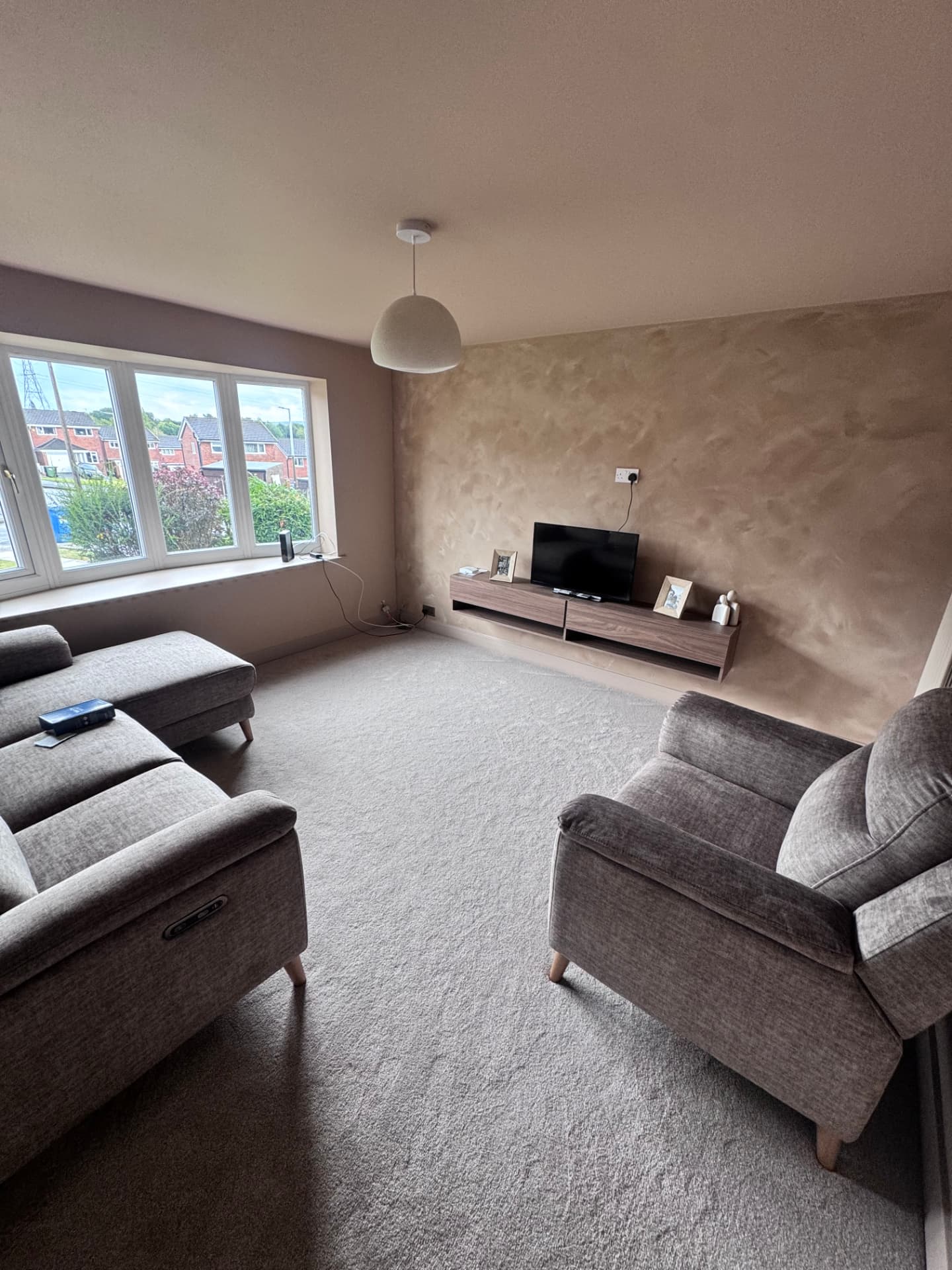 Finished living room with feature plaster wall and floating media unit