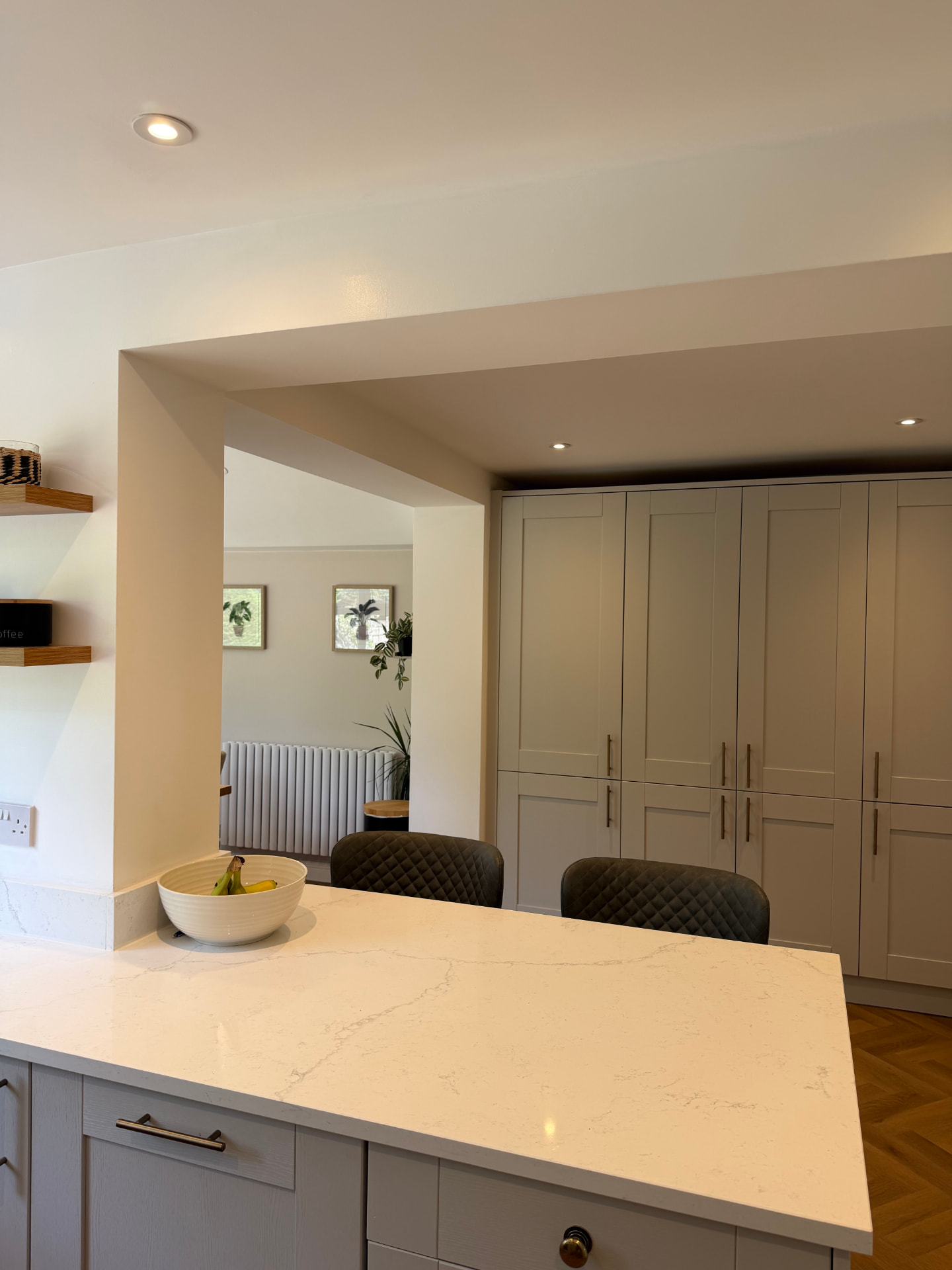 Stone-topped breakfast bar and tall units through the new opening