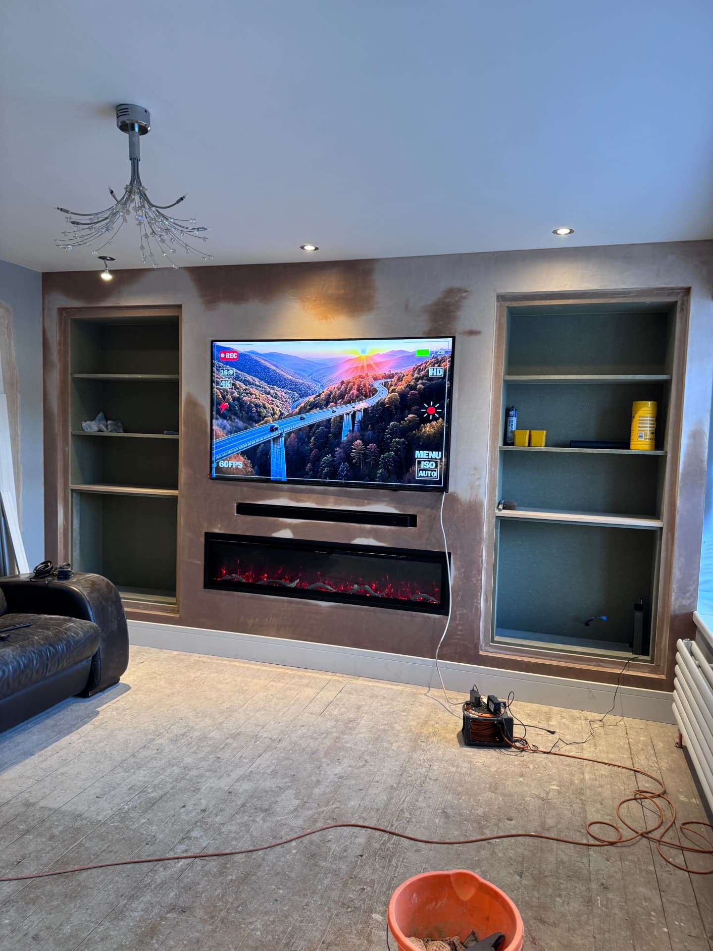 Newly plastered media wall with recessed fire and symmetrical alcove shelving