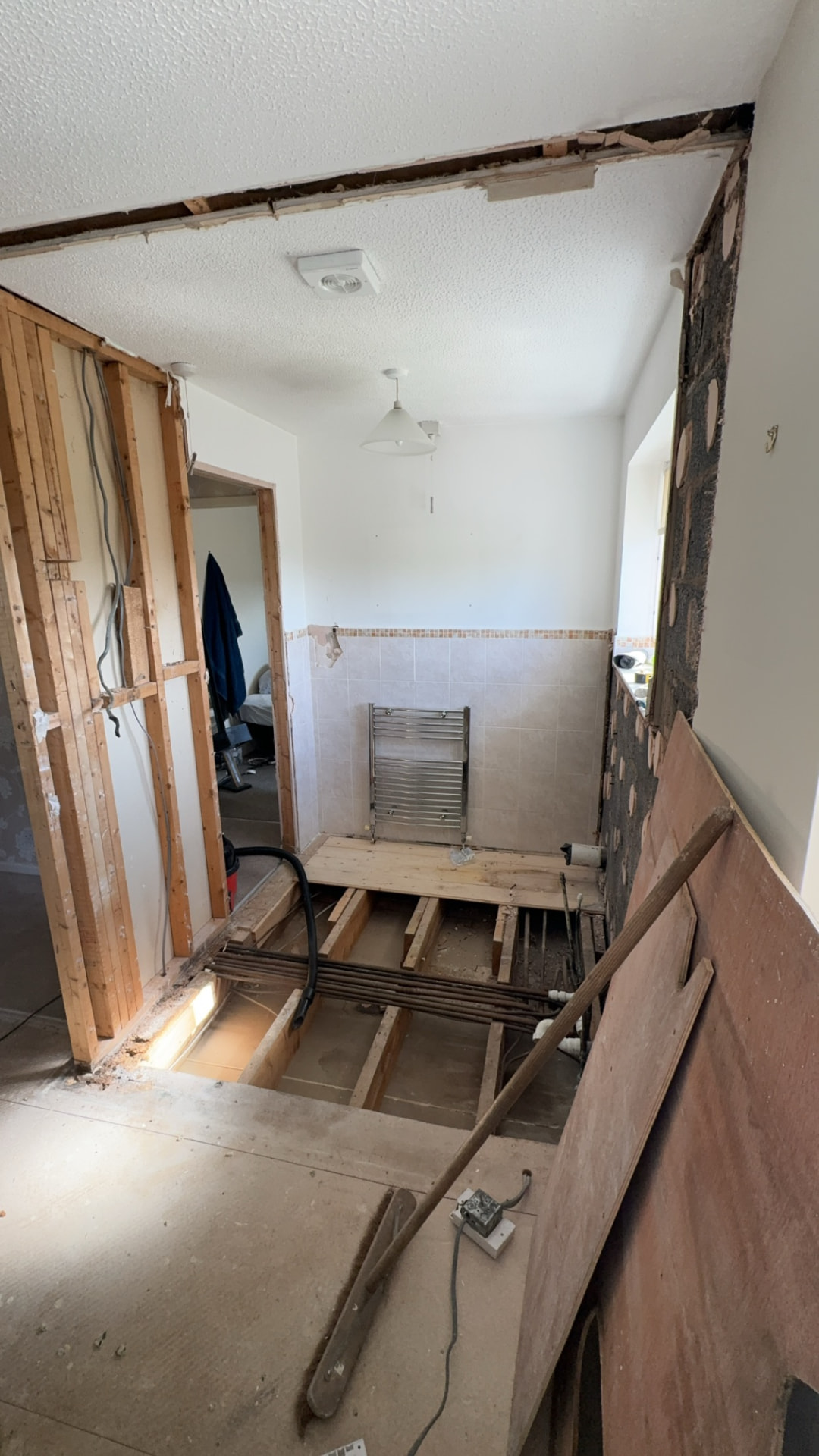 Bathroom stripped back with floorboards up and pipework exposed