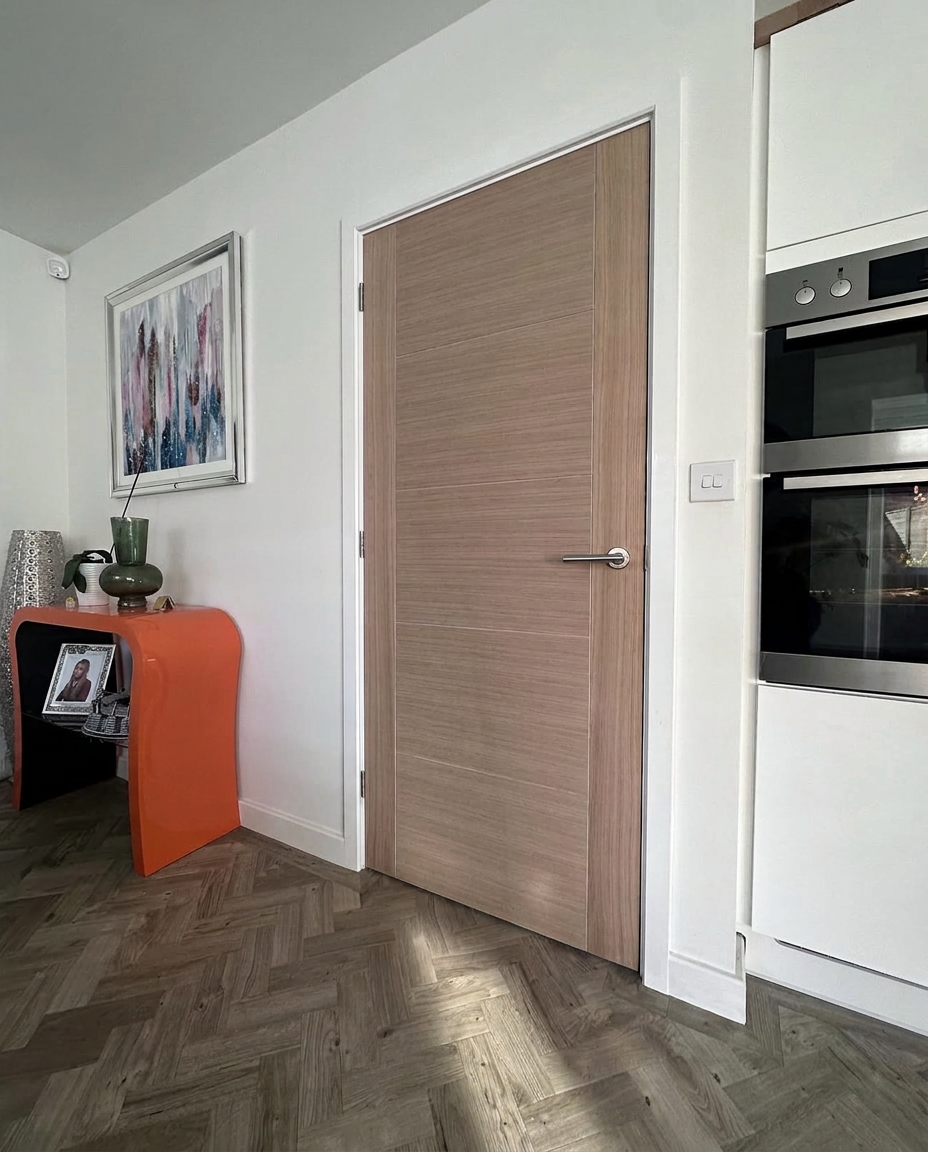 Oak internal door fitted in a modern kitchen with herringbone flooring