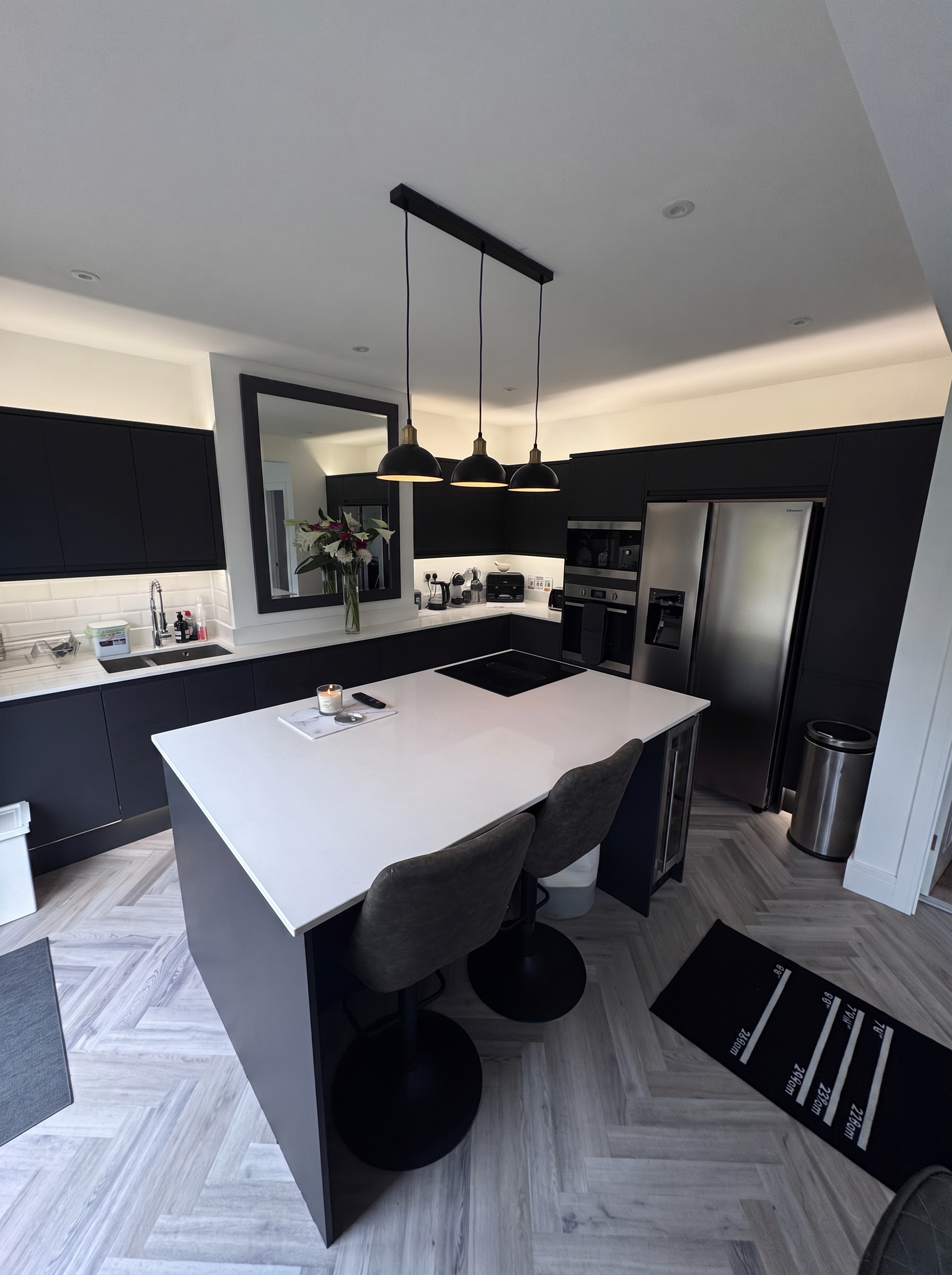 Navy shaker kitchen renovation with quartz island and herringbone oak flooring